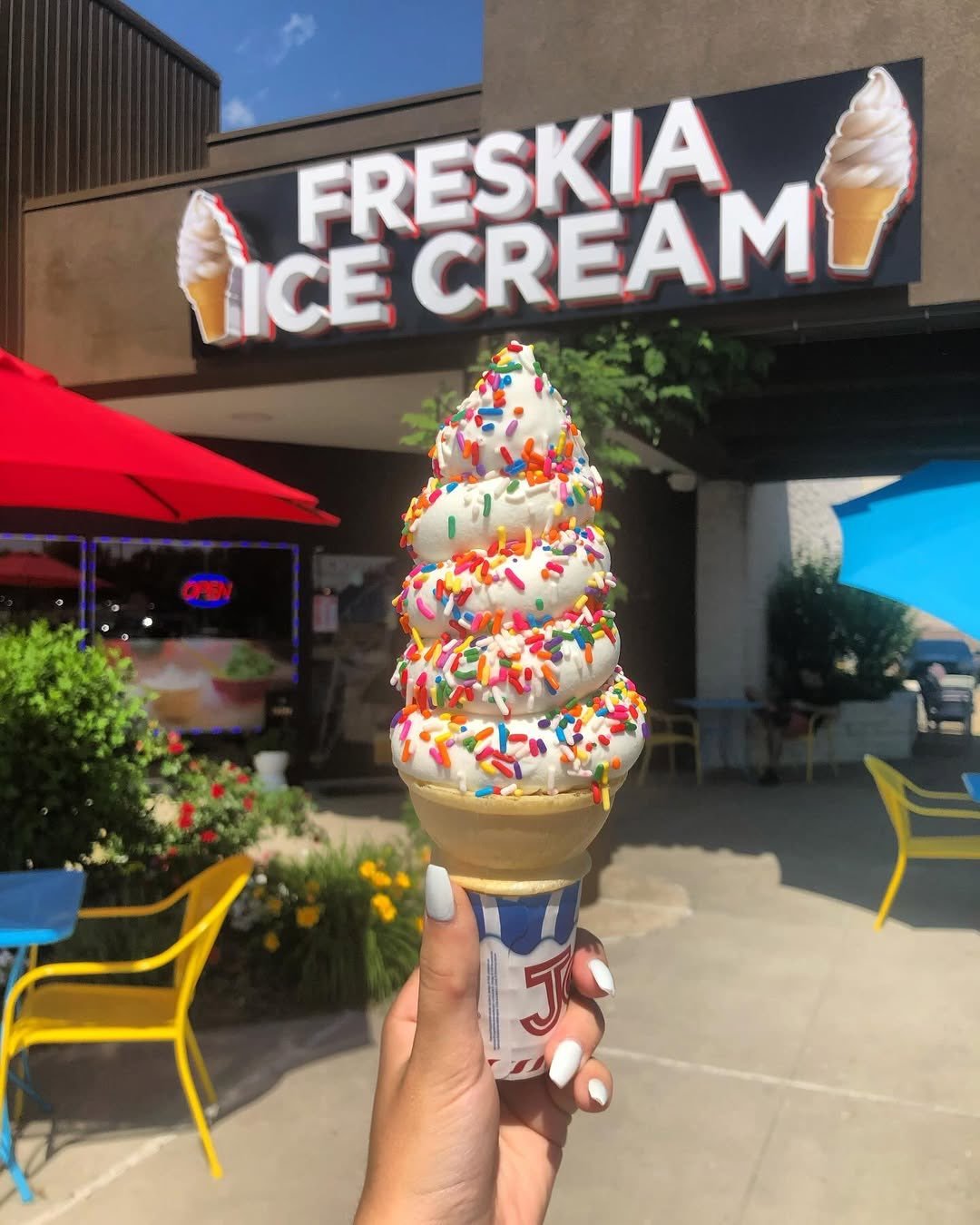 Freskia soft-serve ice cream cone with rainbow sprinkles